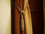 Golden sari curtain tiebacks holding a panel open