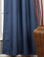 Blue raw silk rod pocket curtains hung at a window