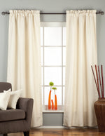 Cream raw silk rod pocket curtains hung at a window