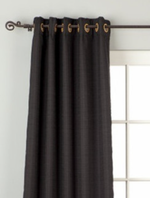 Black raw silk grommet top curtains hung at a window