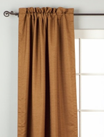 Brown raw silk rod pocket curtains hung at a window