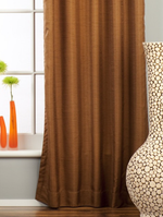 Brown raw silk ring top curtains hung at a window
