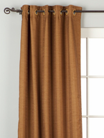 Brown raw silk ring top curtains hung at a window