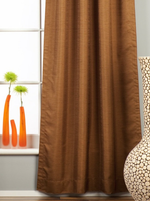 Brown raw silk tab top curtains hung at a window