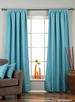 Turquoise raw silk tab top curtains hung at a window