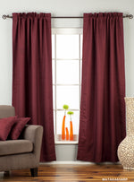 Maroon raw silk rod pocket curtains hung at a window