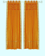Mustard sari grommet top curtains hung at a window