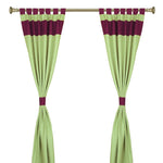 Olive green raw silk tab top curtains hung at a window