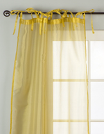 Gold sheer tissue tie top curtains hung at a window