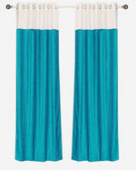 Turquoise velvet ring top curtains hung at a window