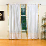 White sari rod pocket curtains hung at a window