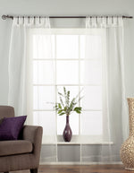White sheer tissue tab top curtains hung at a window