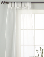 White sheer tissue tab top curtains hung at a window