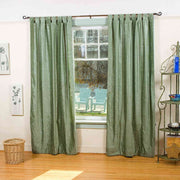 Olive green velvet tab top curtains hung at a window