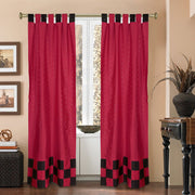 Red sari tab top curtains hung at a window
