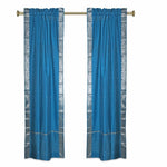 Turquoise sari rod pocket curtains hung at a window