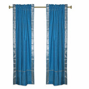 Turquoise sari rod pocket curtains hung at a window