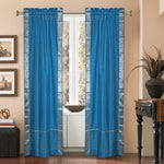 Turquoise sari rod pocket curtains hung at a window