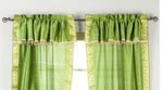 Cream sari rod pocket curtains hung at a window