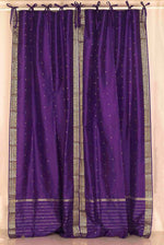 Purple sari tie top curtains hung at a window