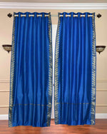 Blue sari grommet top curtains hung at a window