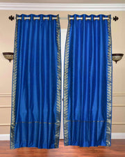Blue sari grommet top curtains hung at a window