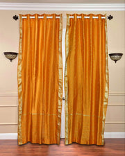 Mustard sari grommet top curtains hung at a window
