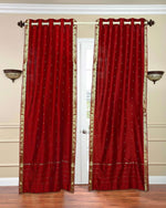 Red sari grommet top curtains hung at a window