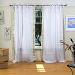 White sari tie top curtains hung at a window