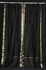 Black sari tie top curtains hung at a window