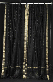 Black sari tie top curtains hung at a window