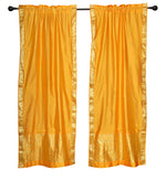 Yellow sari rod pocket curtains hung at a window