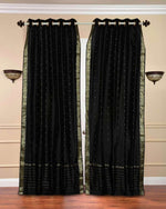 Black sari grommet top curtains hung at a window