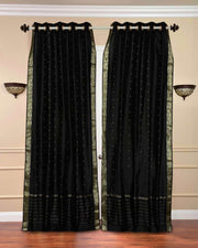 Black sari grommet top curtains hung at a window
