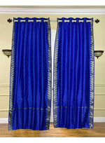 Blue sari grommet top curtains hung at a window