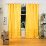 Yellow sari tie top curtains hung at a window