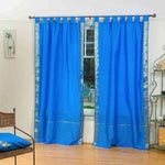 Blue sari tab top curtains hung at a window