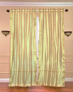 Golden sari grommet top curtains hung at a window