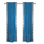 Turquoise sari rod pocket curtains hung at a window