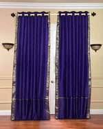 Purple sari grommet top curtains hung at a window