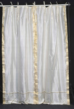 Cream sari tie top curtains hung at a window
