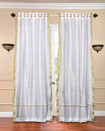 White sari grommet top curtains hung at a window