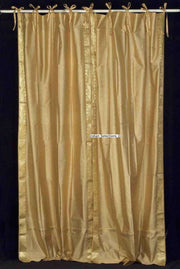 Golden sari tie top curtains hung at a window