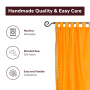 Mustard sari tab top curtains hung at a window