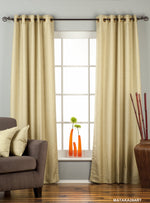 Olive green raw silk grommet top curtains hung at a window