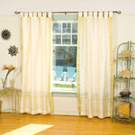 Cream sari tab top curtains hung at a window