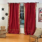 Maroon sari tie top curtains hung at a window