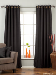 Black raw silk grommet top curtains hung at a window