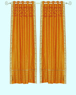 Mustard sari grommet top curtains hung at a window