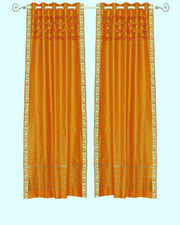 Mustard sari grommet top curtains hung at a window